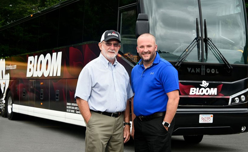 Two men standing by a bus